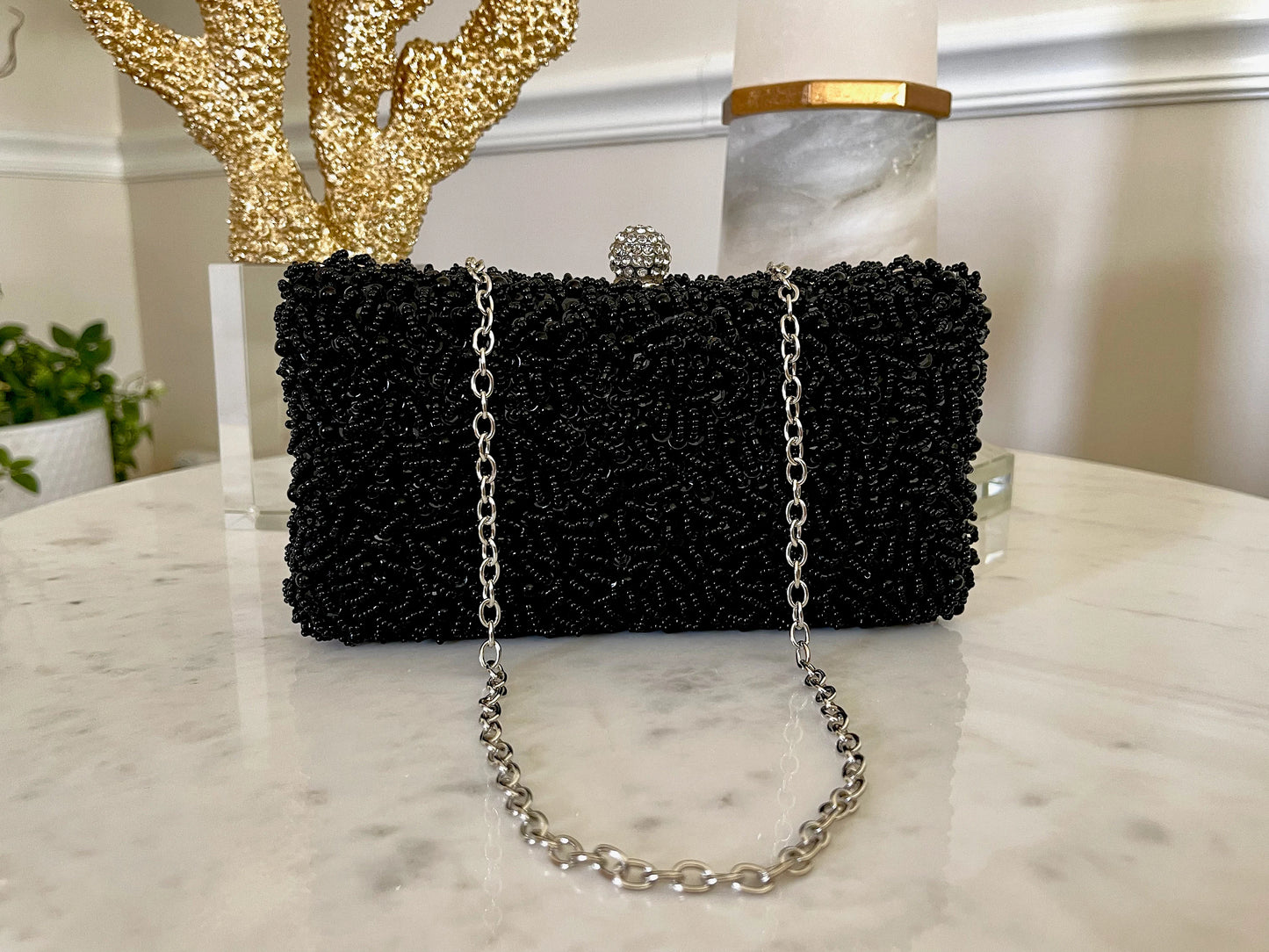 Black Beaded Embroidered Clutch Purse against a marble background, displaying the 46 cm chain attached for crossbody wear