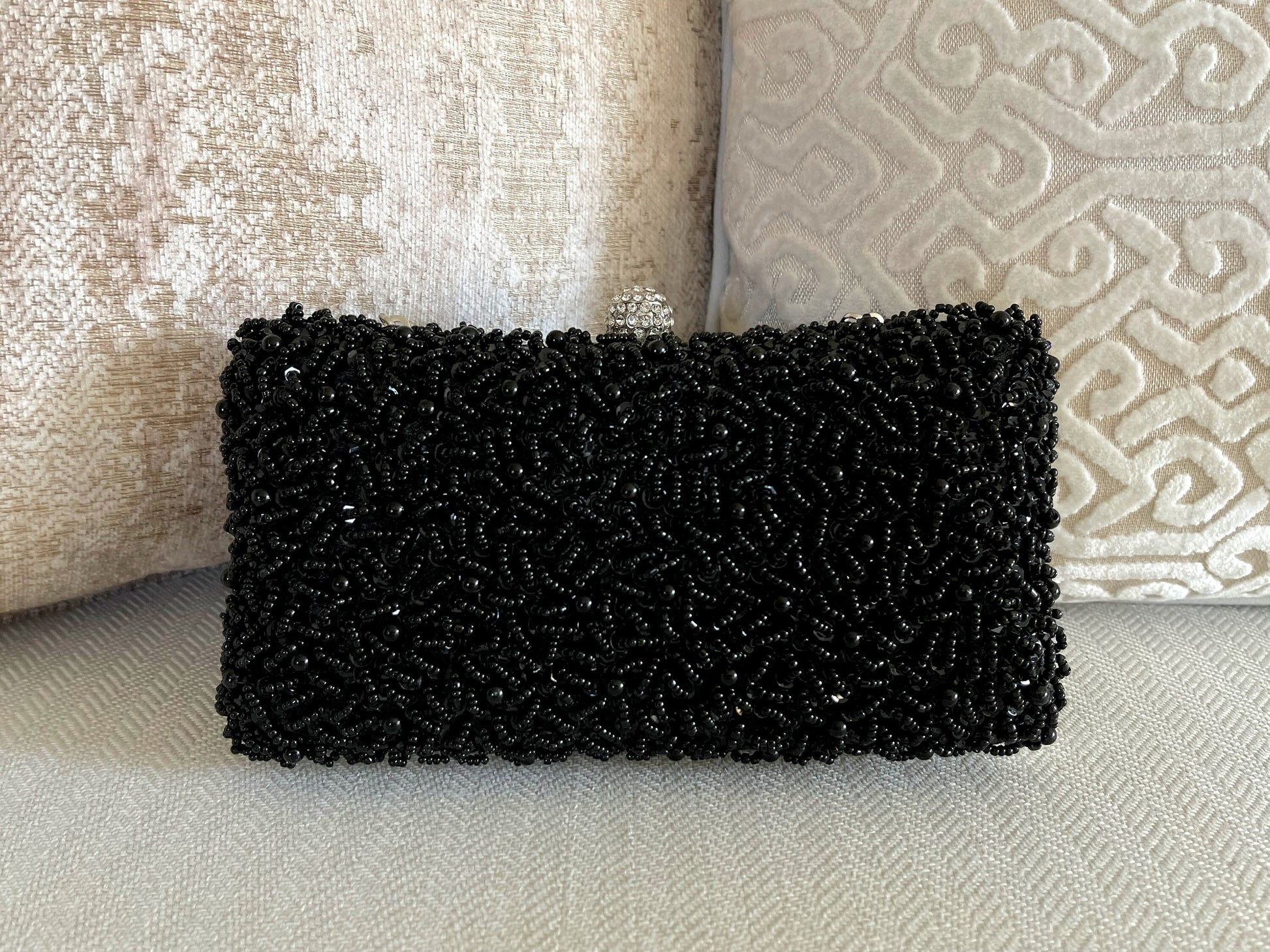 Black Beaded Embroidered Clutch Purse on a marble background, front view showcasing intricate beaded design