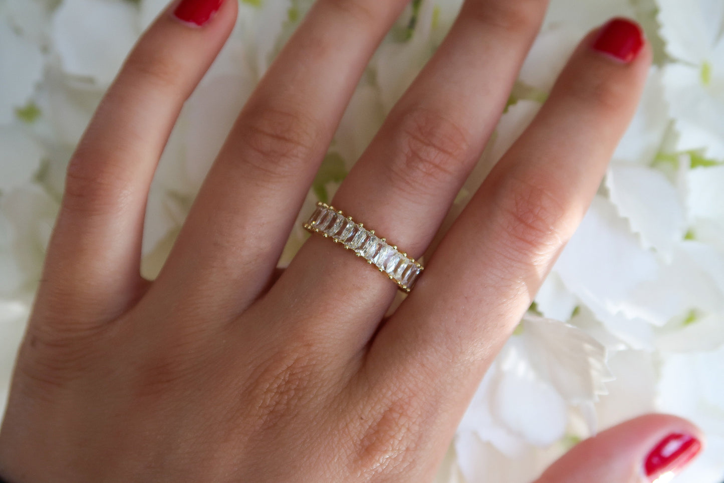 Hand model of gold adjustable cubic zirconia eternity band, front angle 