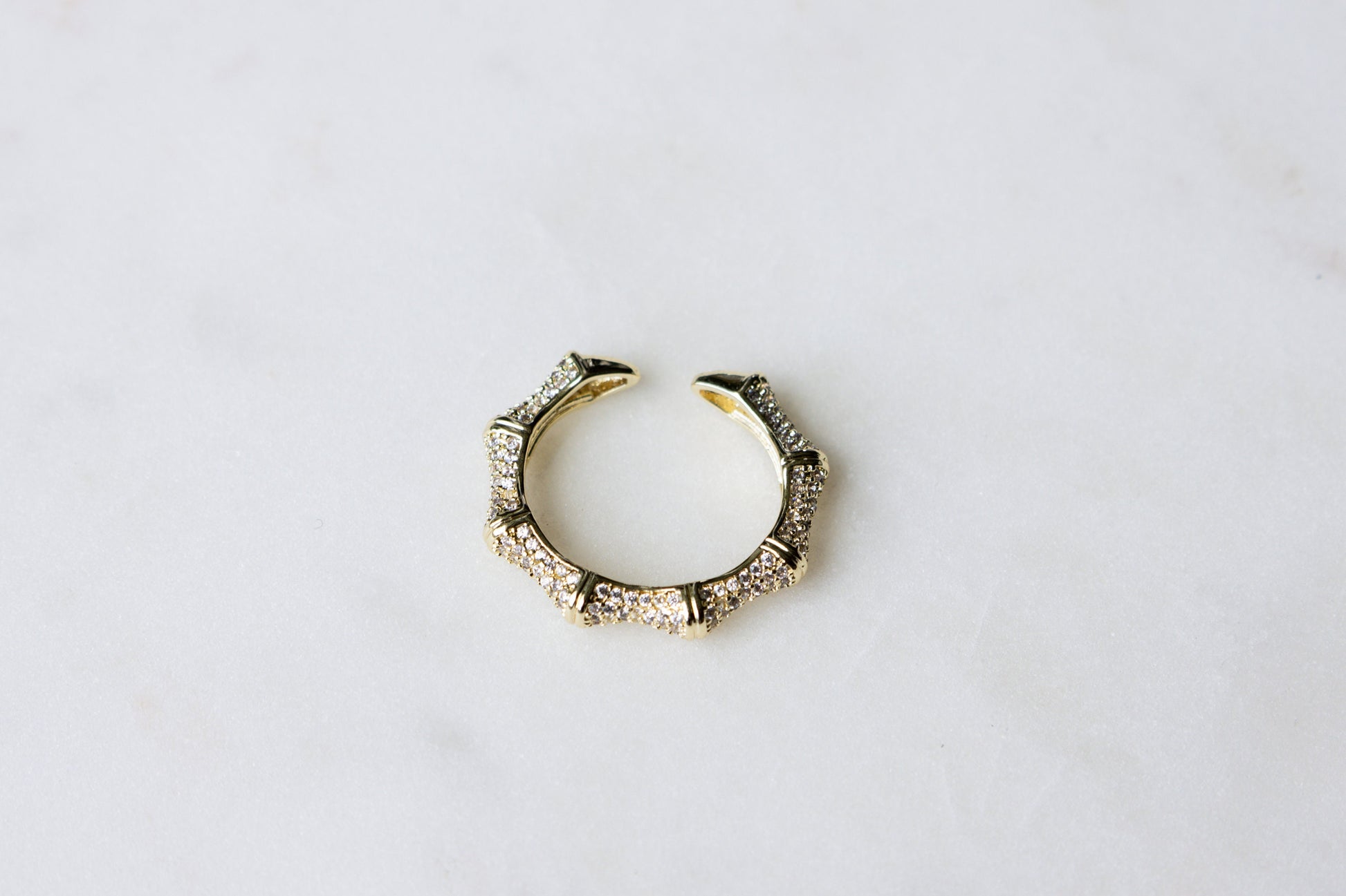 Thin pave ring modeled flat against a white background, highlighting its detailed design.