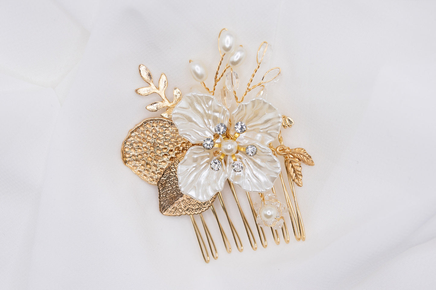 Elegant floral wedding hair pin in gold plating, adorned with rhinestones and faux pearls, displayed against a white background.