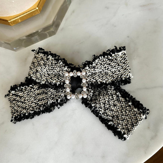 Tweed Clip Hair Bow featuring pearl and crystal embellishments,  against a stylish marble background, showcasing its trendy design.